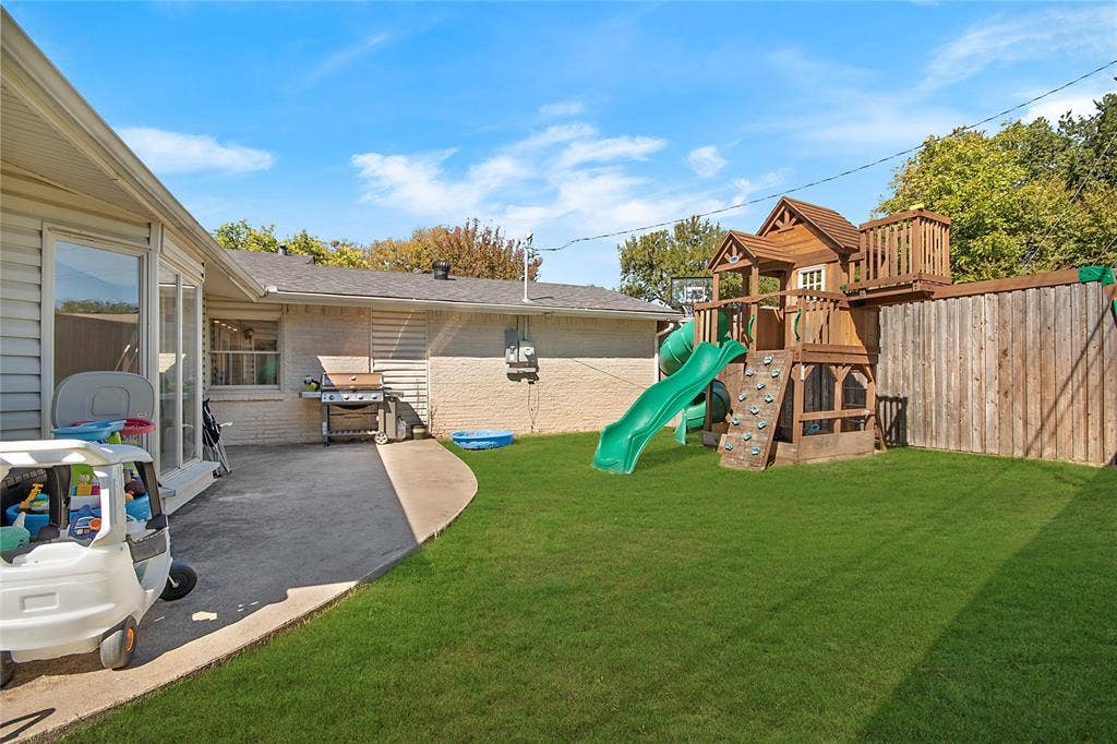 4074 Cedar Bayou Drive, Dallas, TX 75244 Expansive backyard featuring a manicured lawn, concrete patio, and a wood privacy fence