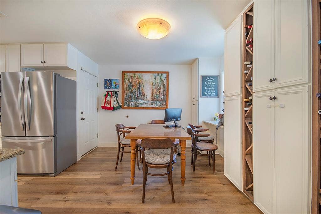 4074 Cedar Bayou Drive, Dallas, TX 75244 Wood-finish flooring, stainless steel refrigerator, white cabinetry, built-in wine storage, and a flush mount ceiling light