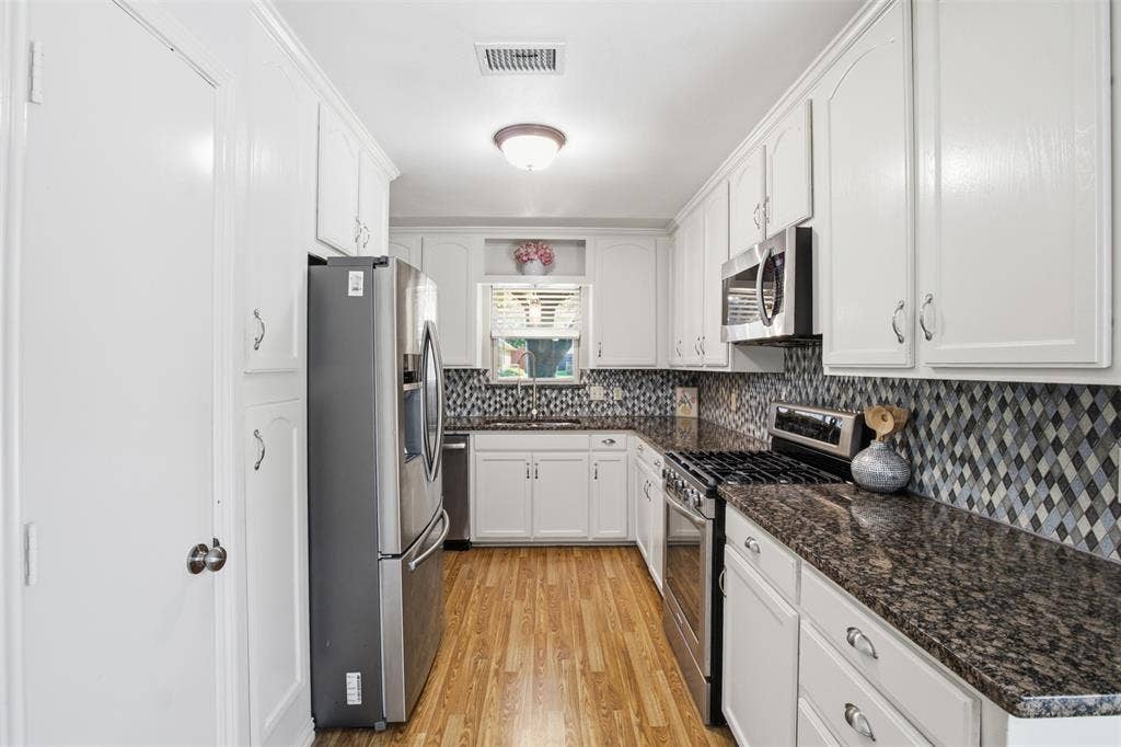 1920 Big Sky Drive, Lewisville, TX 75077 The heart of the home! An updated kitchen with crisp white cabinetry and contrasting countertops.