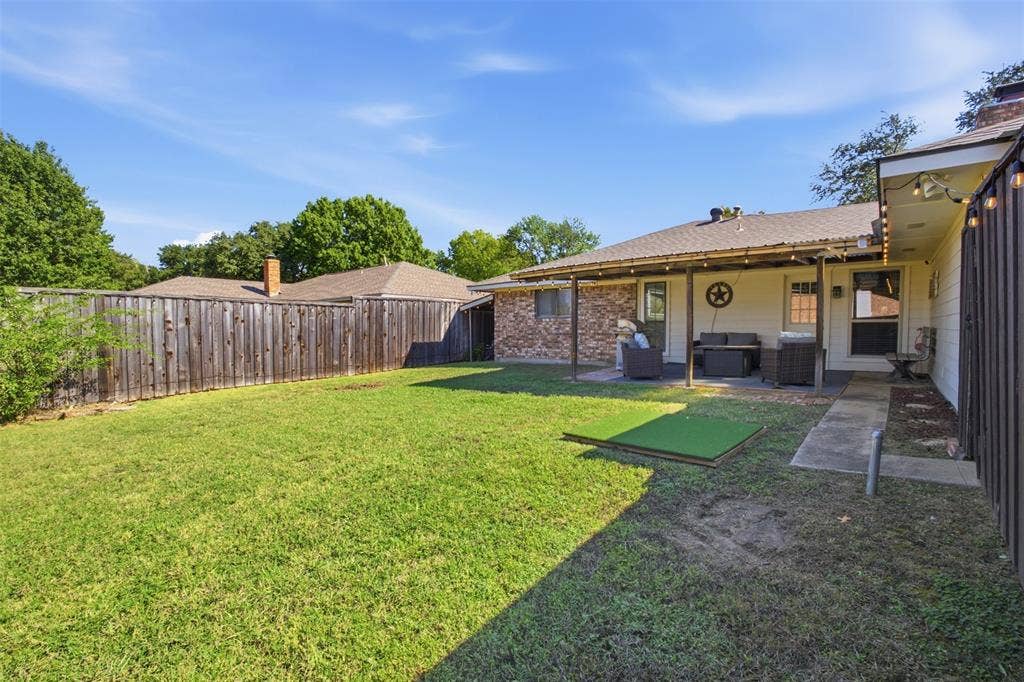 1920 Big Sky Drive, Lewisville, TX 75077 A welcoming backyard with a covered patio, ready for outdoor gatherings or quiet afternoons.