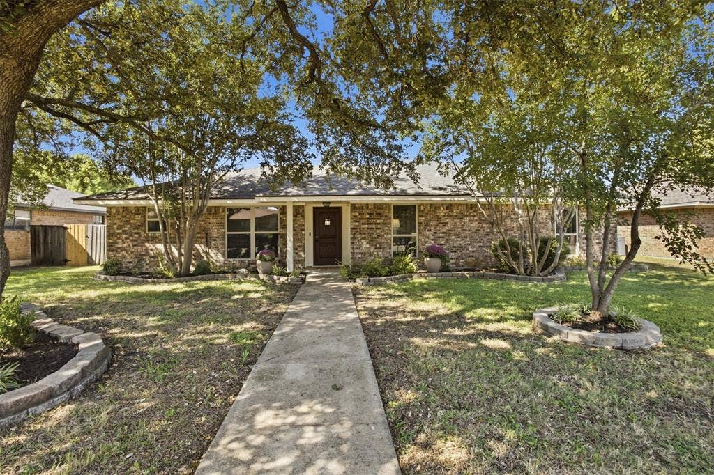 1920 Big Sky Drive, Lewisville, TX 75077 Charming front exterior with a walkway leading to the covered entry.