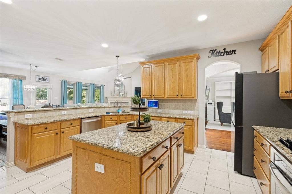 Well-appointed kitchen featuring granite countertops, a large center island, abundant cabinetry, and generous prep space.