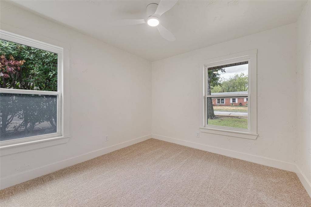 Spacious secondary bedroom with new carpet and dual windows.