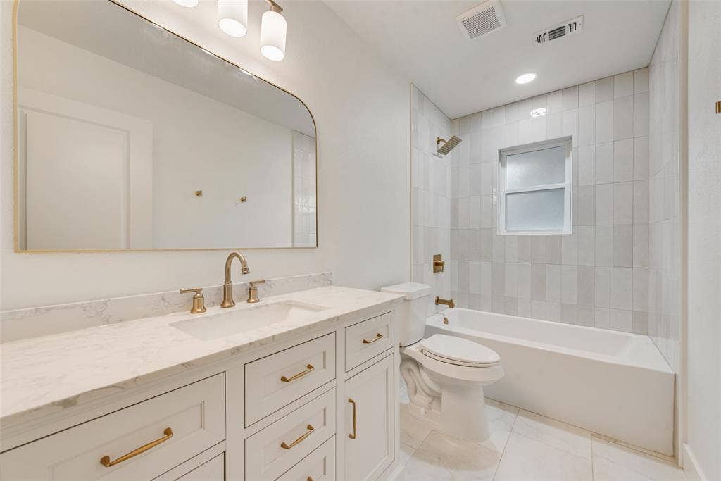Second full bath with extended vanity and tub-shower combination.