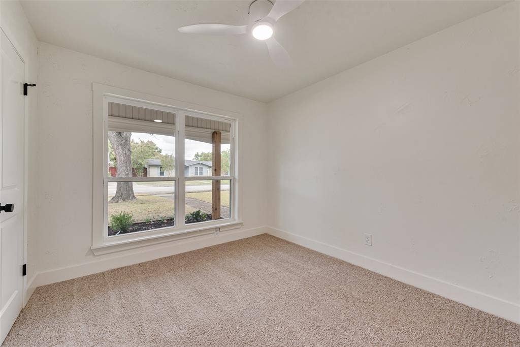 Additional secondary bedroom with new carpet and a large window.