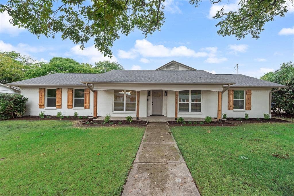 Welcoming front elevation with refreshed landscaping and a spacious front lawn.