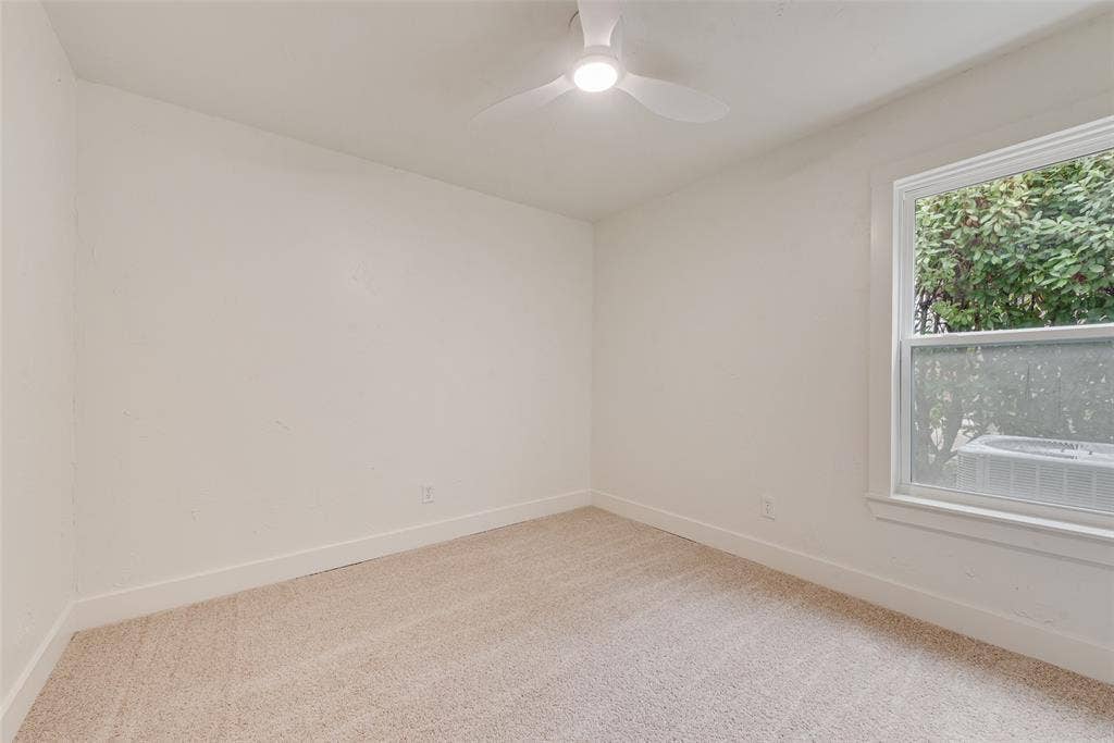 Bright secondary bedroom with new carpet and natural light.