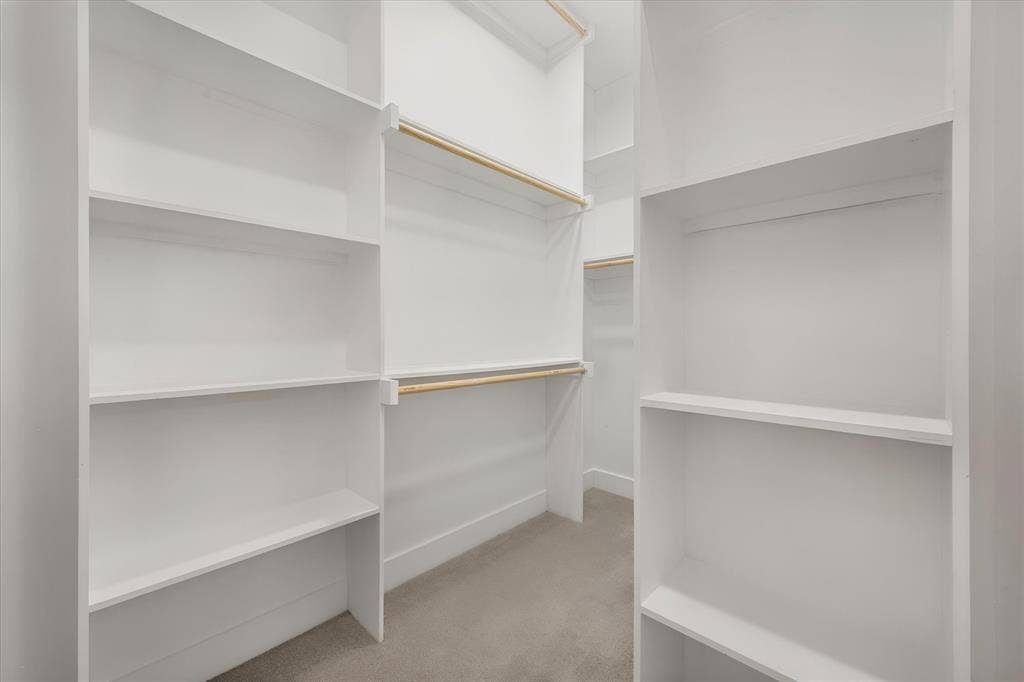 Built-in closet shelving, integrated hanging rods, and light-tone carpeting