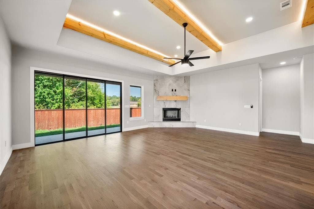 Wood-finish flooring, recessed lighting, and a tray ceiling with integrated lighting