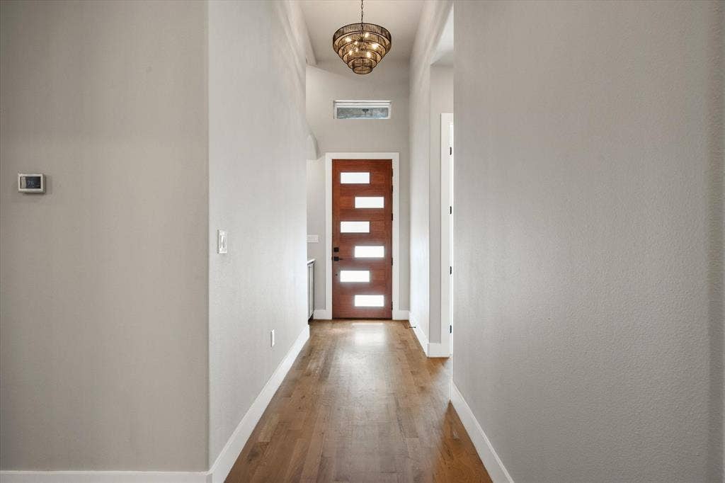 Wood-finish flooring, recessed lighting, and a modern chandelier