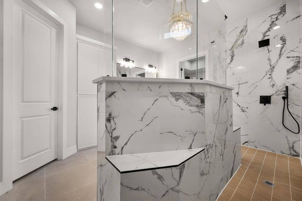 Walk-in shower with full height tile, integrated seating, glass enclosure, and wood-finish flooring