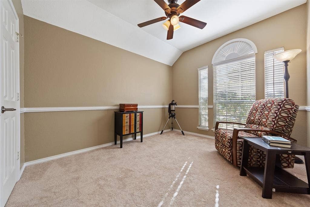 Vaulted ceiling with a ceiling fan, arched transom window, and paneled interior door