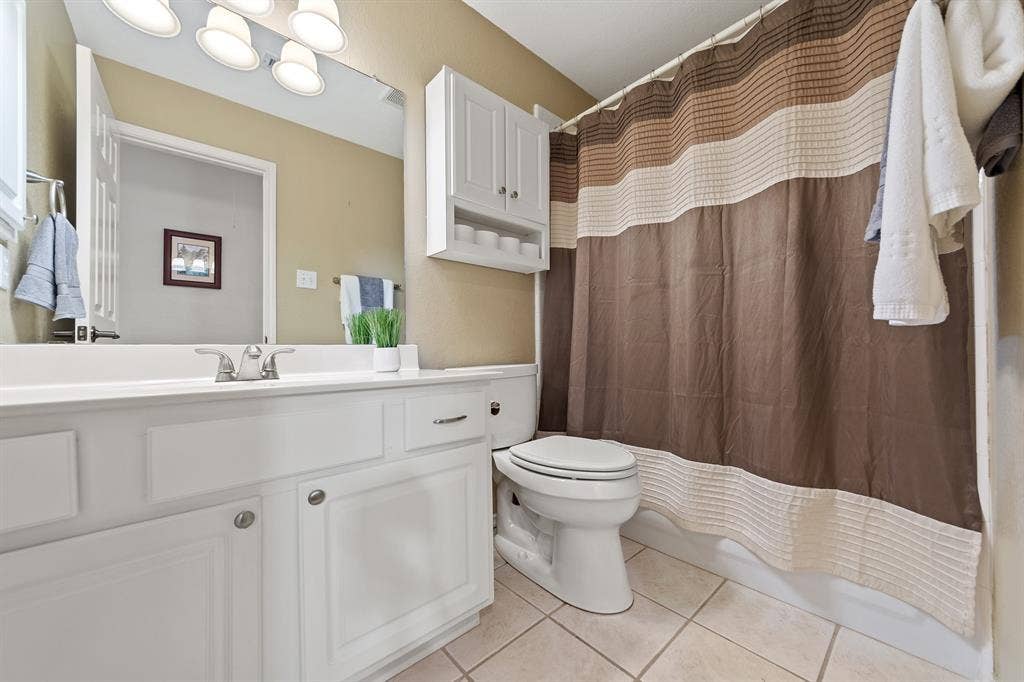 White vanity with cabinet storage, integrated sink, and chrome faucet