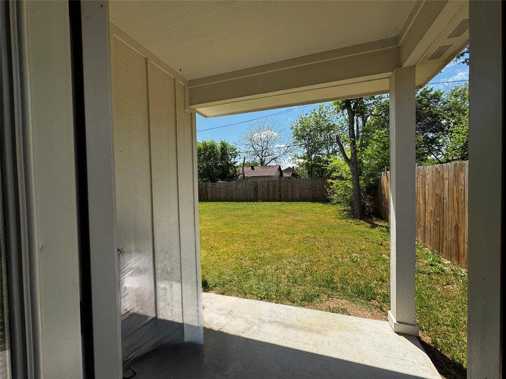 3207 NW 30th Street, Fort Worth, TX 76106 Covered patio with concrete flooring, overlooking a green lawn and wood fencing