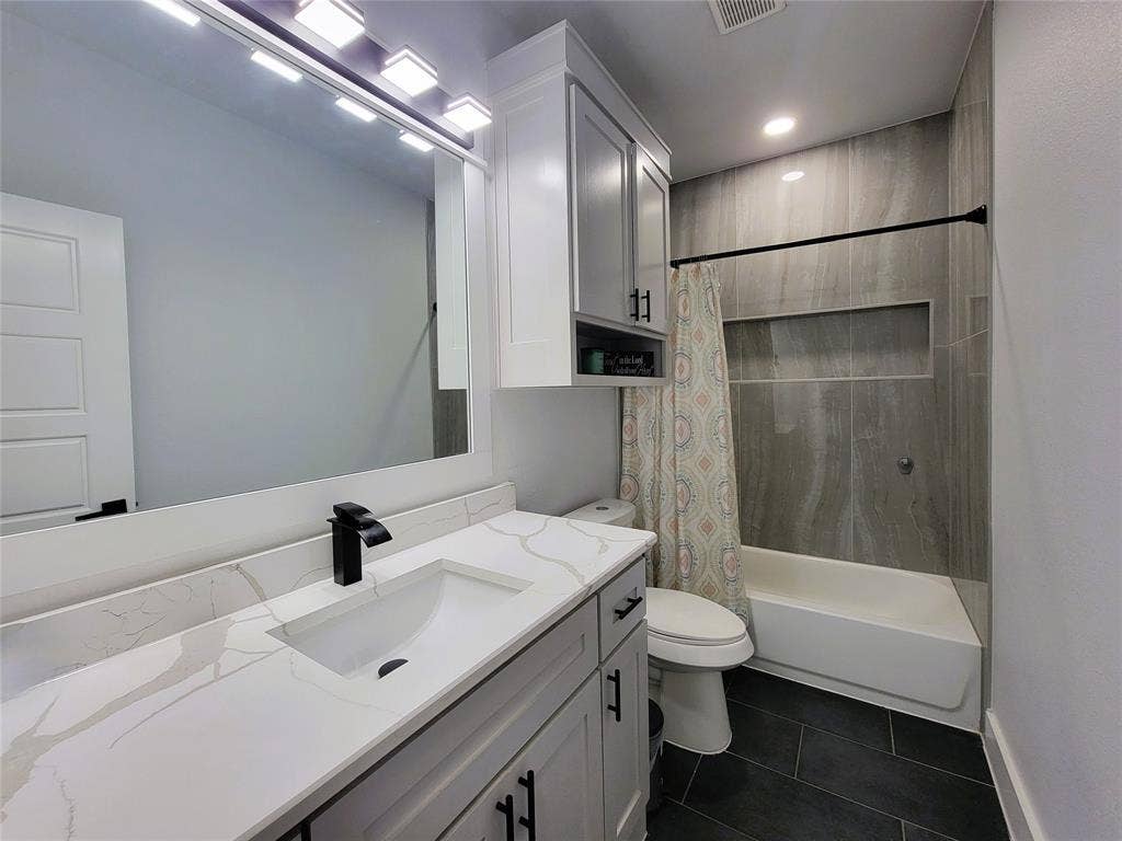 3207 NW 30th Street, Fort Worth, TX 76106 Built-in vanity with a single basin sink, white countertop, and matte black faucet