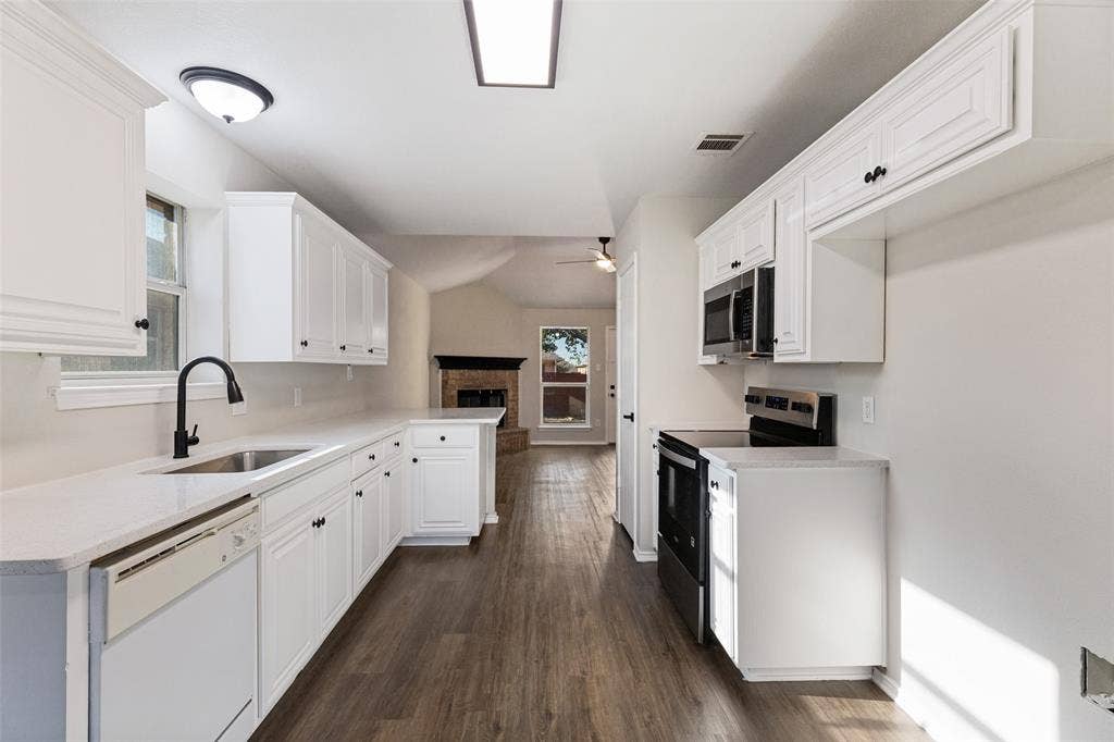 4545 Grainland Court, Fort Worth, TX 76179 White cabinetry, light-toned countertops, wood-finish flooring, and stainless steel appliances
