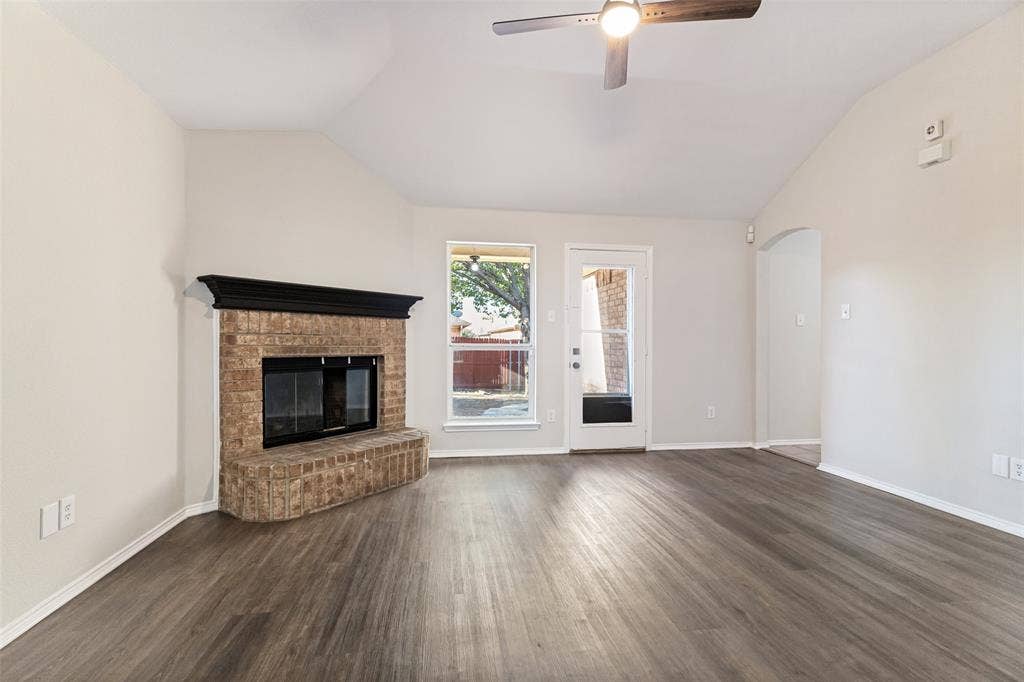 4545 Grainland Court, Fort Worth, TX 76179 Vaulted ceiling, ceiling fan, wood-finish flooring, brick fireplace with a dark mantel, and an exterior door with glass paneling
