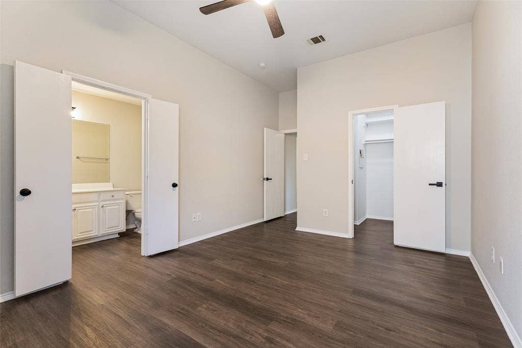 4545 Grainland Court, Fort Worth, TX 76179 Vaulted ceiling with a ceiling fan, wood-finish flooring, and white interior doors with black hardware