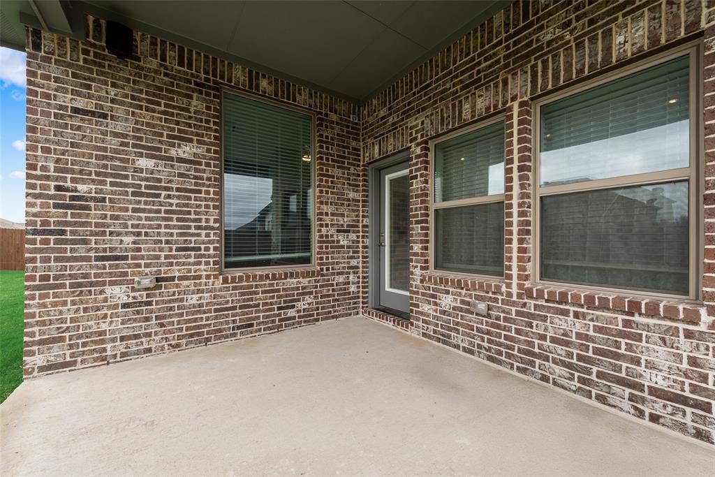 107 White Sands Lane, Forney, TX 75126 Covered patio featuring brick exterior, concrete flooring, and multiple windows