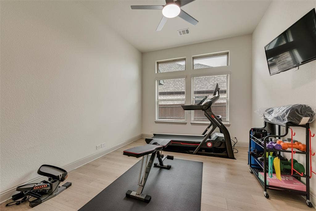 107 White Sands Lane, Forney, TX 75126 Study currently used as an exercise room, with wood-finish flooring, a ceiling fan, and windows with blinds