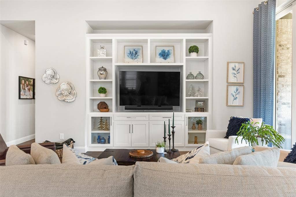 9716 Wilderness Road, Little Elm, TX 75068 Living room with integrated built-in cabinetry, wood-finish flooring, recessed lighting, and large sliding glass doors