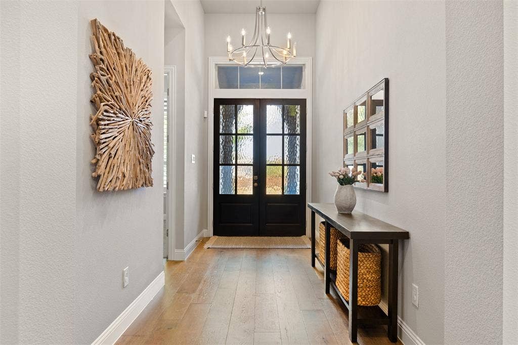 9716 Wilderness Road, Little Elm, TX 75068 Entryway featuring a double door with textured glass, transom window, and wood-finish flooring