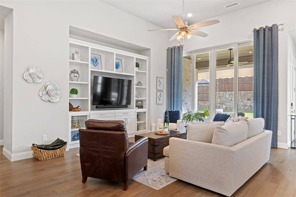 9716 Wilderness Road, Little Elm, TX 75068 Living room with integrated built-in cabinetry, wood-finish flooring, recessed lighting, and large sliding glass doors