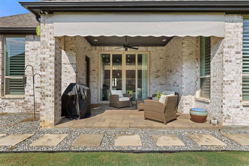9716 Wilderness Road, Little Elm, TX 75068 Covered patio featuring a ceiling fan and a retractable awning