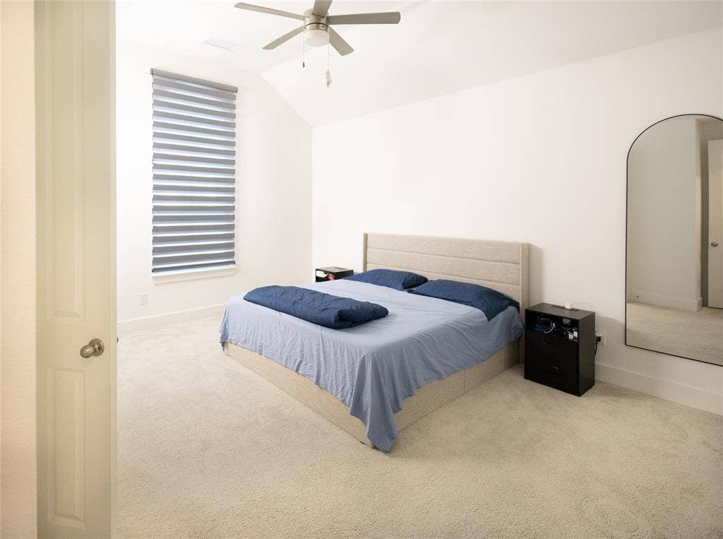 3017 Andorra Road, McKinney, TX 75071 Vaulted ceiling featuring a ceiling fan, window with horizontal blinds, and light-colored carpeting