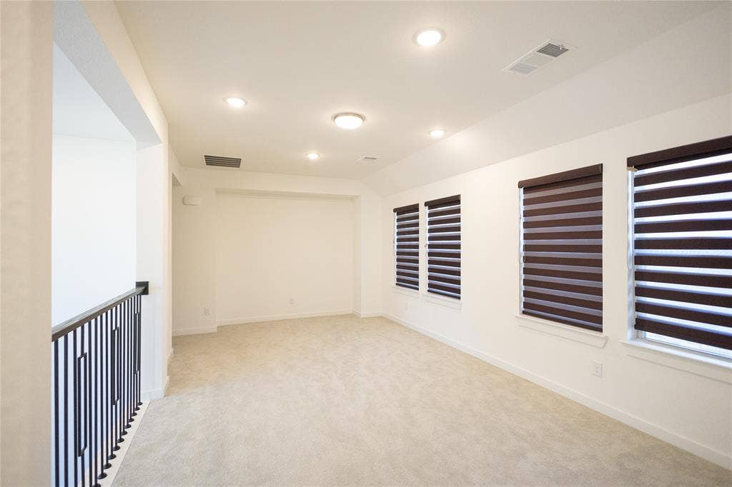 3017 Andorra Road, McKinney, TX 75071 Recessed ceiling lighting, multiple windows with blinds, light-colored carpeting, and a black wrought iron railing