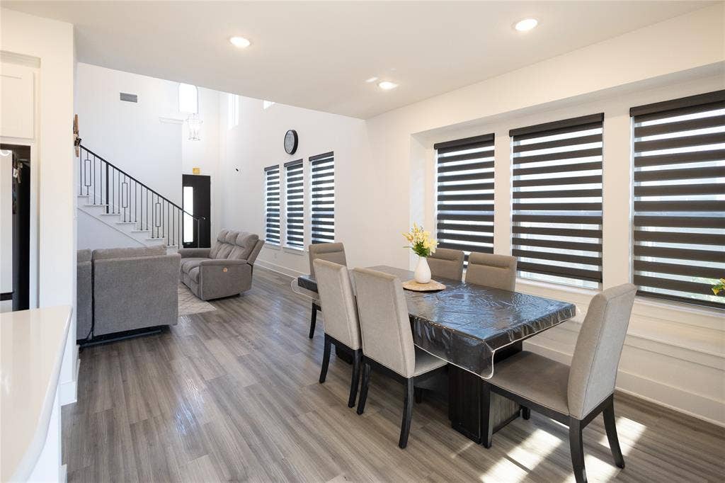 3017 Andorra Road, McKinney, TX 75071 Open-concept living space featuring wood-finish flooring, recessed lighting, and a staircase with a black metal railing