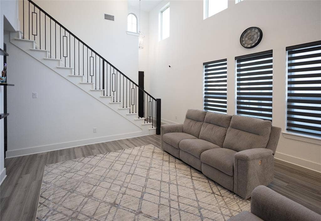 3017 Andorra Road, McKinney, TX 75071 Two-story ceiling, wood-finish flooring, staircase with contemporary metal balusters, high windows, and three vertical windows
