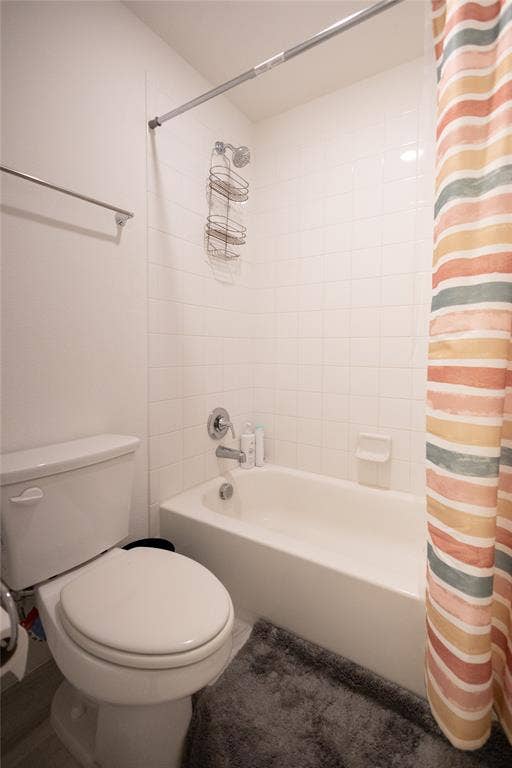 3017 Andorra Road, McKinney, TX 75071 White tile shower surround with a built-in tub, chrome fixtures, and a white toilet