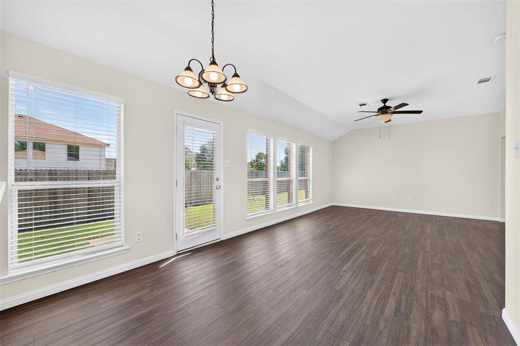 2724 Douglas Drive, McKinney, TX 75071 Dining and living areas with a ceiling fan, easy care LVP flooring, multiple windows, and a glass-paneled back door