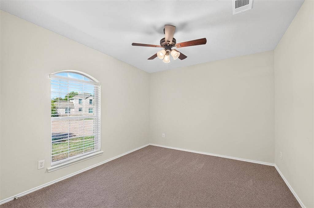 2724 Douglas Drive, McKinney, TX 75071 Arched window with blinds, ceiling fan with integrated lighting, and fresh neutral carpeting