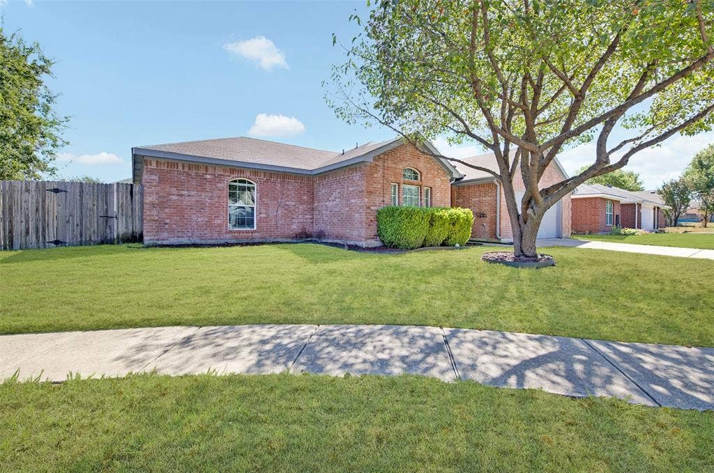 2724 Douglas Drive, McKinney, TX 75071 Brick exterior with an arched windows, a mature tree, and a concrete sidewalk