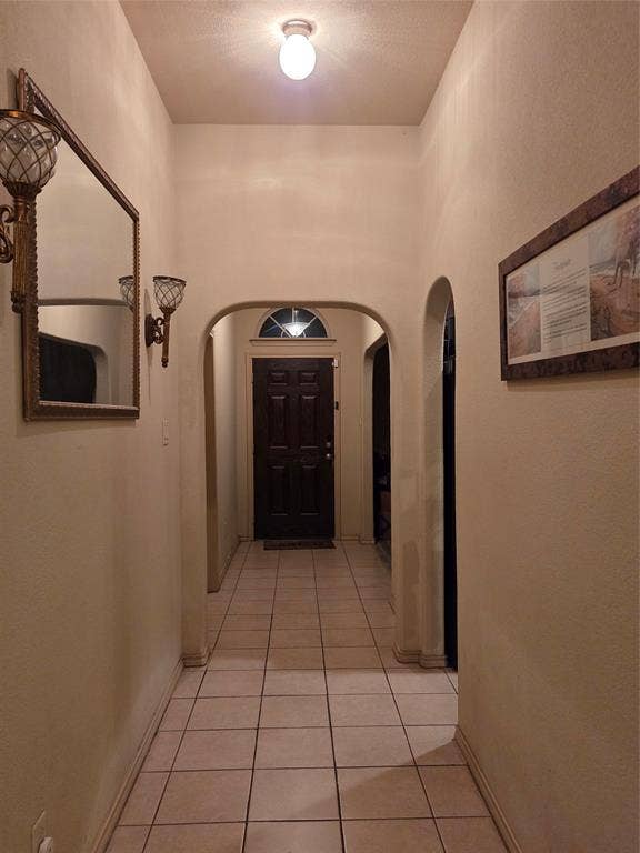 1026 Rio Vista Drive, DeSoto, TX 75115 Recessed entry with arched doorways, tile flooring, and a paneled entry door with transom window