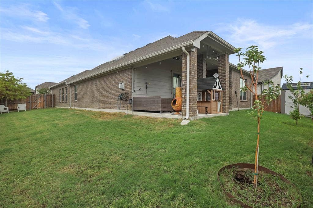 6152 Cobbetts Pond Lane, Fort Worth, TX 76179 Expansive backyard featuring a covered patio, brick exterior, and a privacy fence