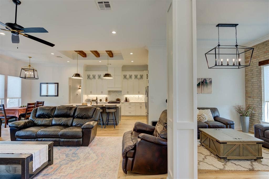 Open-concept living area with wood-finish flooring, recessed lighting, and a ceiling fan