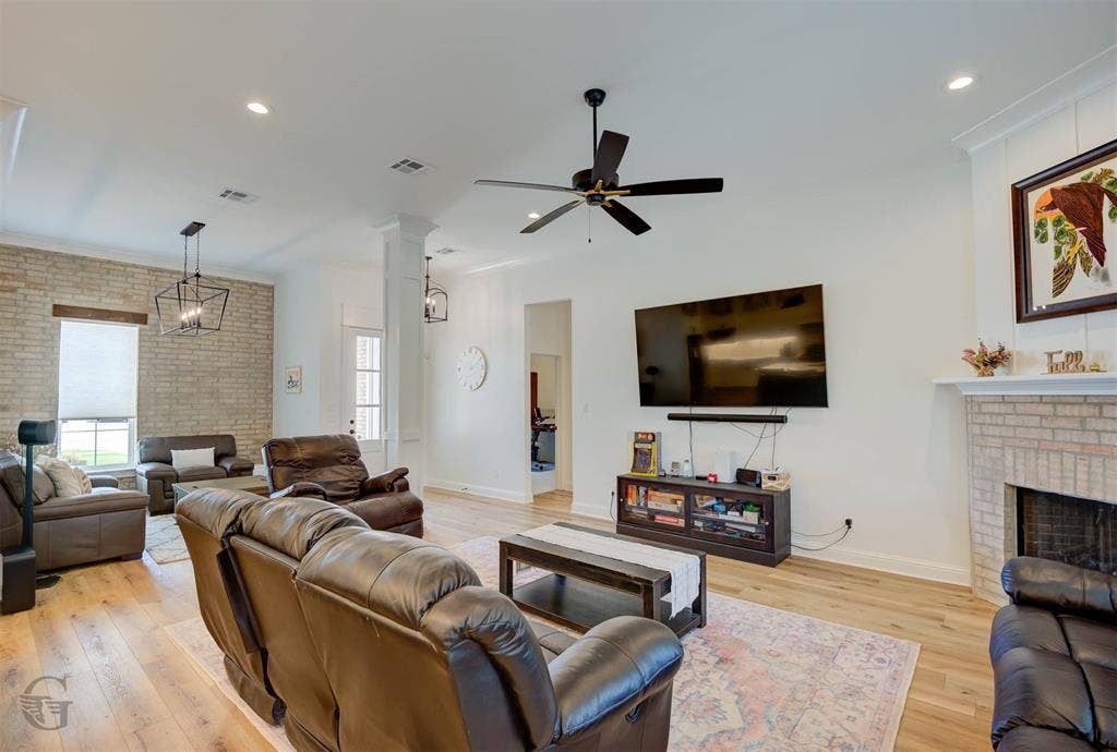Spacious living area featuring wood-finish flooring, recessed lighting, and a ceiling fan