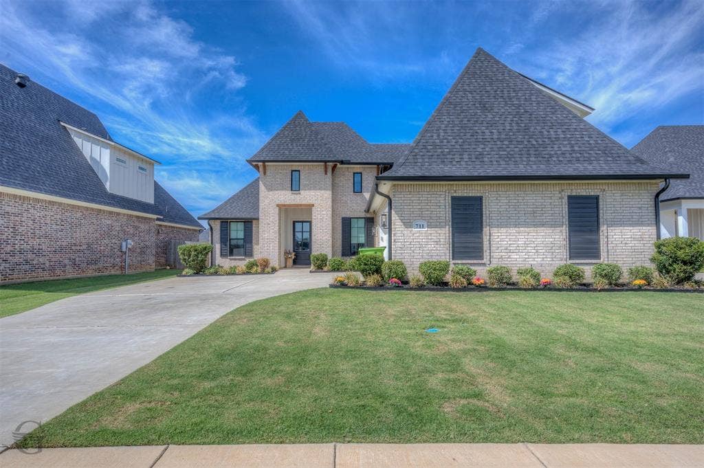 Light brick exterior with dark shingle roofing