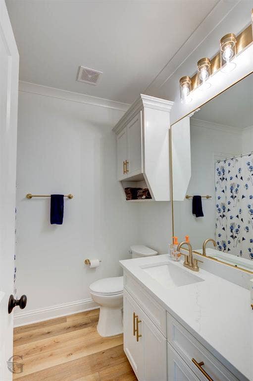 White vanity with a single basin, gold-finish hardware, and a gold-finish faucet