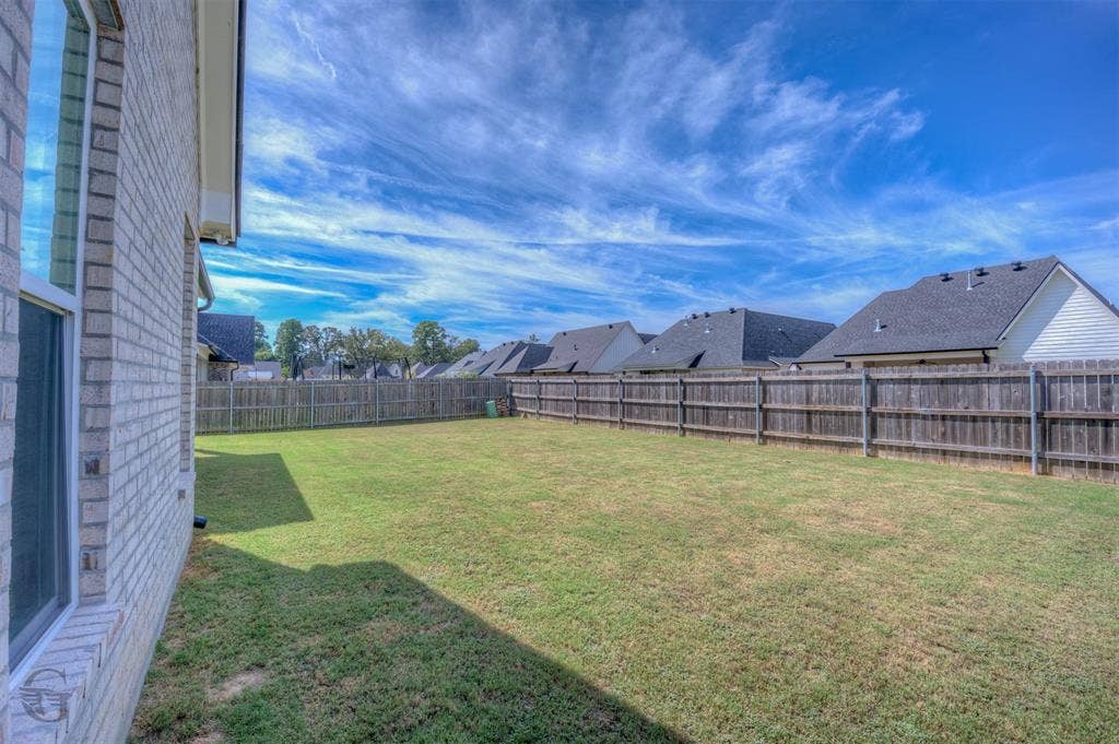 Expansive lawn area with a wood privacy fence
