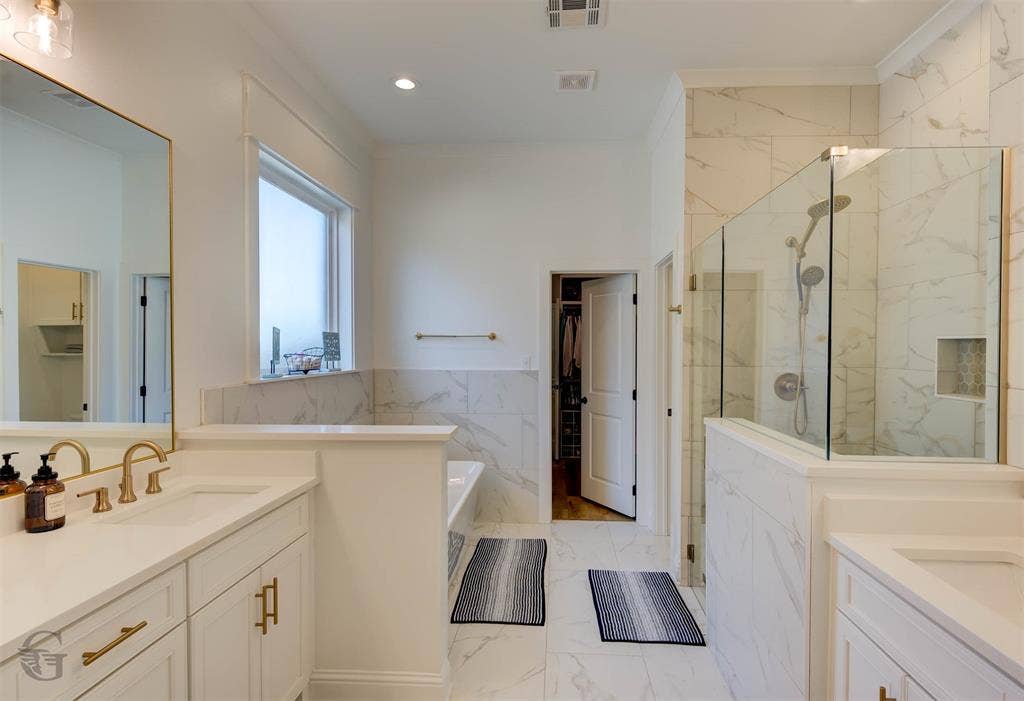 Dual vanity with white cabinetry and gold-tone hardware