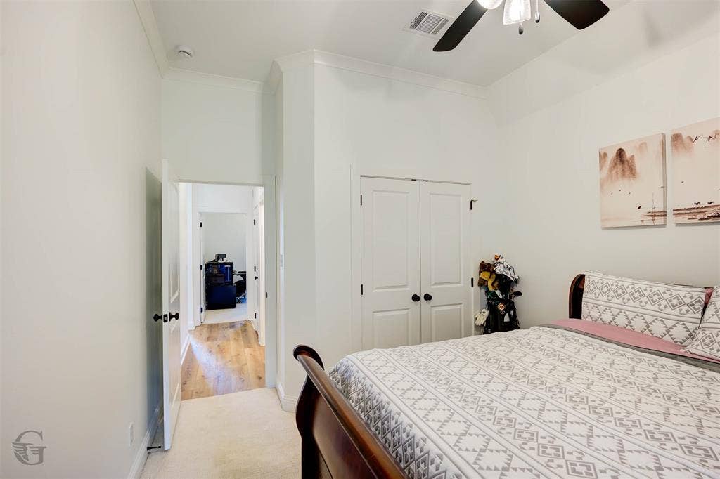 Recessed closet with double doors, crown molding, and a ceiling fan with integrated lighting