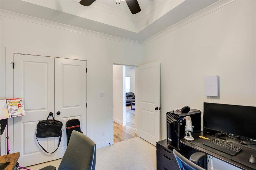 Tray ceiling with crown molding, double white panel doors, and light-toned wall finishes