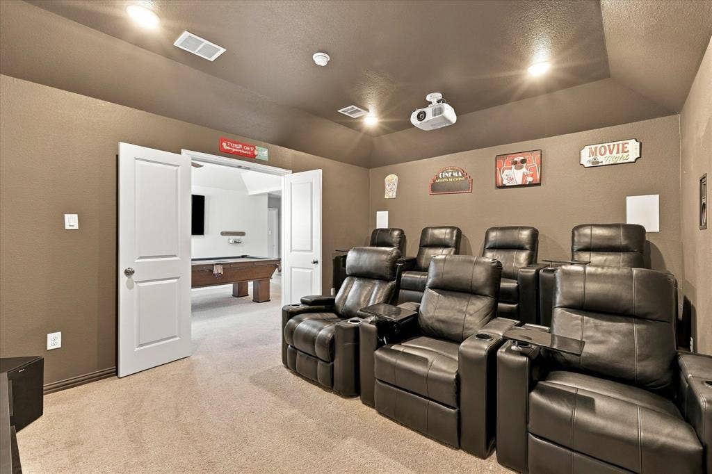 Carpeted media room with recessed lighting and a ceiling-mounted projector