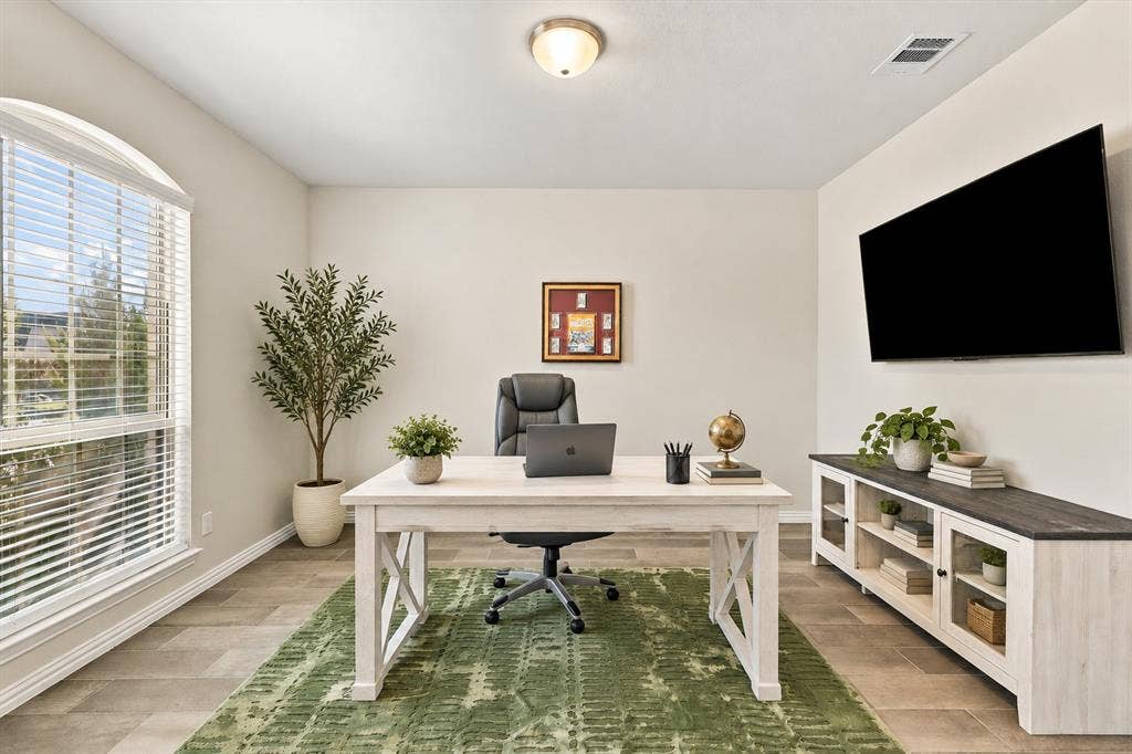 Arched window with blinds, recessed ceiling light, wall-mounted display, and tile flooring