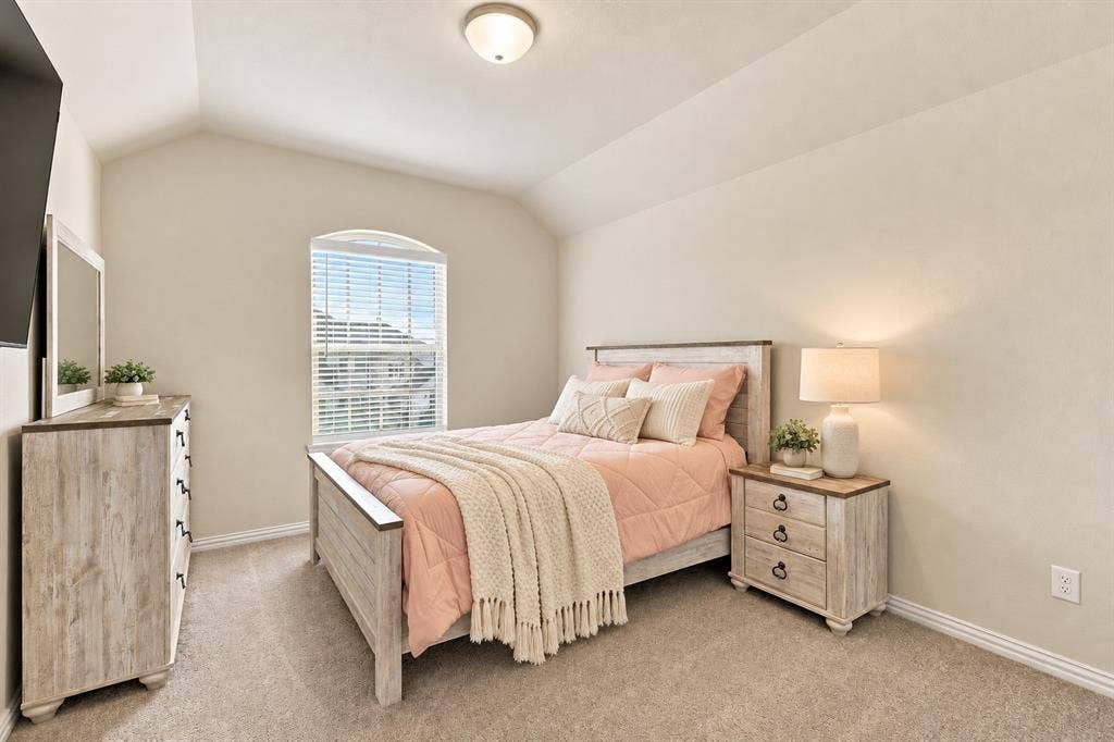 Arched window with blinds, vaulted ceiling, recessed lighting, and neutral carpeting