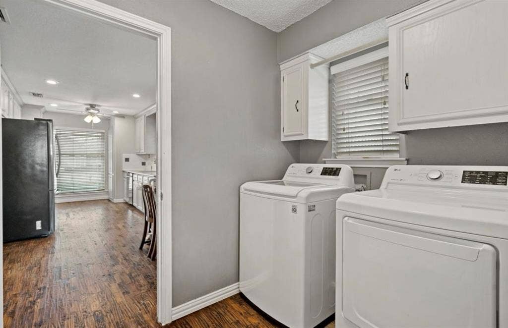 1603 Vicksburg Drive, Sachse, TX 75048 Clothes washing area featuring ceiling fan, separate washer and dryer, dark wood-style flooring, baseboards, and cabinet space